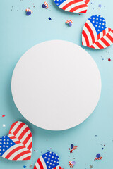 Obraz premium Freedom Fest festivities. Vertical top view of representative ornaments: hearts with American flag motif, sparkling confetti on a soft blue background with a blank circle for text or promotion