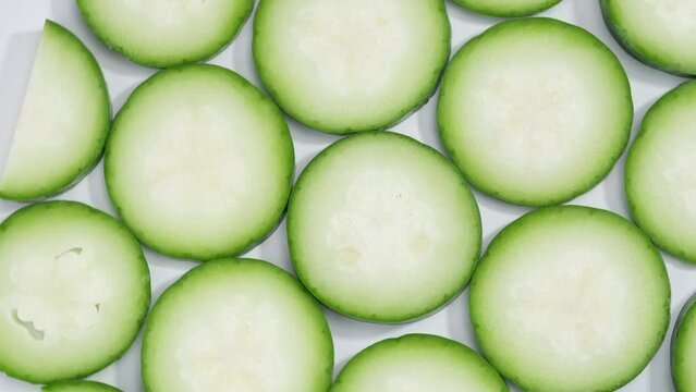 Close up view with a lot of winter melon round slices spread evenly on rotating table. Winter melon (Benincasa hispida) may reduce the threat of several types of cancers