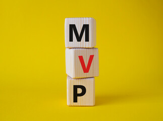 MVP - Most Valuable Player symbol. Wooden cubes with words MVP. Beautiful yellow background....