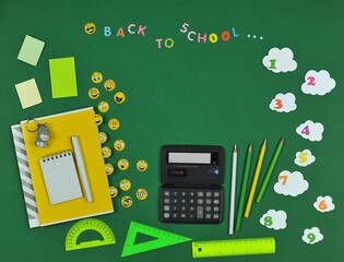 Back to school green background with school accessories and funny emoji. Top view ,flat lay. Free copy space.