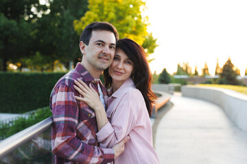 Obraz premium A romantic couple, a man and a woman, hug in the park.
