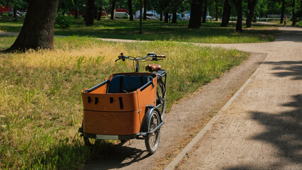 Wooden E-cargo bike parking in a park in Berlin. Bright summer day. Grass in foreground. Eco...