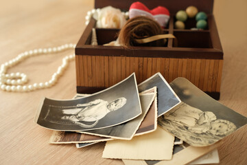 dear to heart memorabilia in an old wooden box, a stack of retro photos, a wooden rosary, vintage...