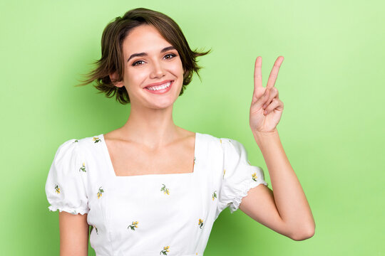 Photo of nice lady good mood positive person showing v sign symbol wear white vintage shirt isolated green color background