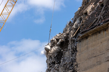 Heavy wrecking ball crane demolishing old building against blue sky in Magdeburg Germany. Building...