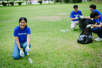 Fototapeta premium Multiethnic volunteers donate their time holding black garbage bags to collect plastic waste for recycling to reduce pollution in a public park.