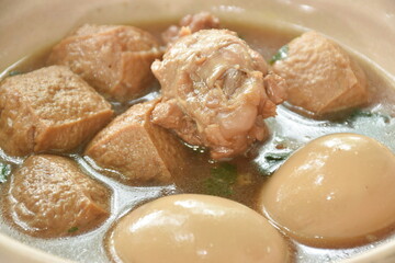 Fototapeta na wymiar boiled egg with chicken drumstick with fried tofu in herb brown soup on bowl 