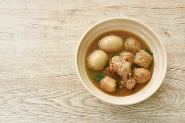 boiled egg with chicken drumstick with fried tofu in herb brown soup on bowl 