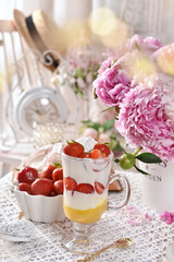 Strawberry dessert and fresh fruits on the table in vintage style with peonies