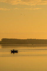 Wędkarz w łódce łowiący ryby nad zalewem