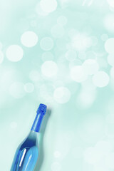 Aesthetic Top view sparkling wine, blue bottle of wine with sunlight flare, bokeh on turquoise background, Happy holidays summer monochrome card, Festive summer party alcohol drink concept