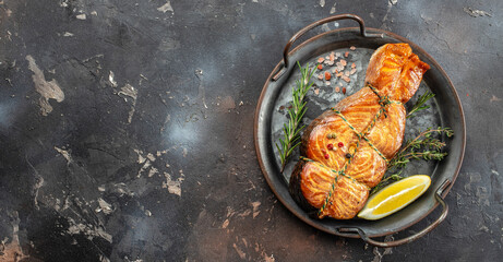baked salmon grilled lemon and salt on a dark background. Long banner format. top view
