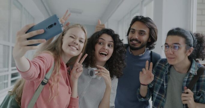 Slow motion of happy girls and guys high school students taking selfie with smartphone camera posing laughing. Photography and youth lifestyle concept.
