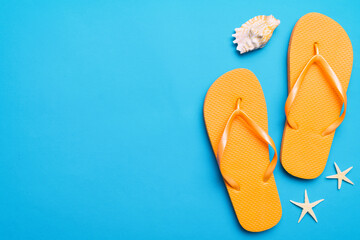 Flat lay composition with flip flops and seashell on colored background. Space for text top view