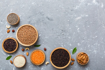 Various superfoods in smal bowl on colored background. Superfood as rice, chia, quinoa, lentils, nuts, sesame seeds, almonds. top view copy space