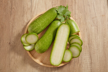 Top view of a wooden tray in round-shaped containing many round slices of winter melon. Winter melon (Benincasa hispida) is rich in vitamin C and antioxidants that improve skin health