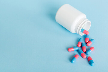 plastic medicine bottle with capsules of pills on colored background. Online pharmacy. Painkiller medicine and antibiotic drug resistance concept. Pharmaceutical industry