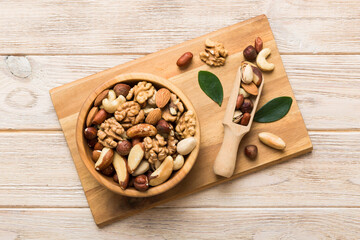 Fototapeta na wymiar mixed nuts in bowl. Mix of various nuts on colored background. pistachios, cashews, walnuts, hazelnuts, peanuts and brazil nuts