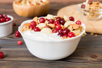 Healthy breakfast food with granola, yogurt, fruits and nuts. Dessert parfait with dried fruits for breakfast