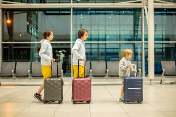Children with suitcases at airport, walking at night for a flight