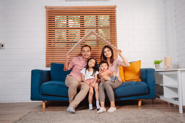 Obraz premium Happy Family home insurance roof protecting house and daughter. holding cardboard covering for family protection.