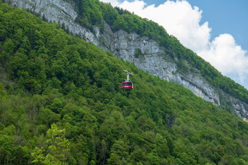 Fototapeta na wymiar Large red funicular cabin taking tourists up the mountain in the Swiss Alps