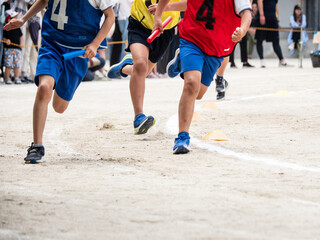 小学校の運動会でリレーを走る子供