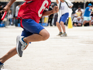 小学校の運動会でリレーを走る子供