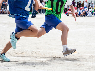 小学校の運動会でリレーを走る子供