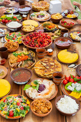 Homemade Romanian Food with grilled meat, polenta and vegetables Platter on camping. Romantic traditional moldavian food outside on the wood table.
