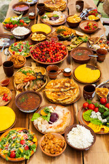 Homemade Romanian Food with grilled meat, polenta and vegetables Platter on camping. Romantic traditional moldavian food outside on the wood table.