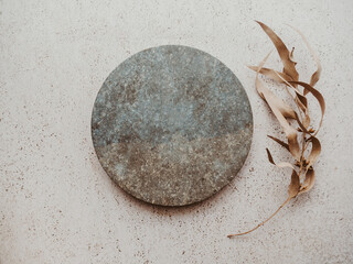 Marble gray round podium and dry eucalyptus branch on beige texture background