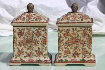 A pair of old ceramic lidded jars with a floral pattern. Ginger jars