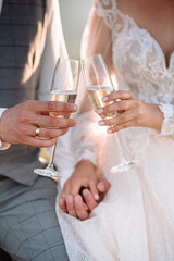 Wedding glasses in hands bride and groom