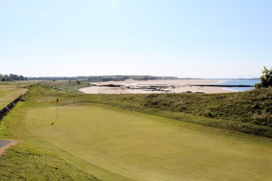 An incredible view of a golf hole in Scotland with the ocean in the background in North Berwick, East Lothian, Scotland