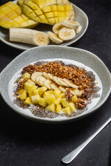 Granola with yogurt, mango, banana and chia in a bowl