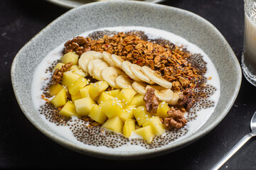 Granola with yogurt, mango, banana and chia in a bowl