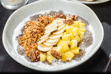 Granola with yogurt, mango, banana and chia in a bowl