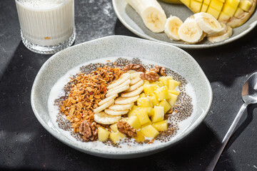 Granola with yogurt, mango, banana and chia in a bowl