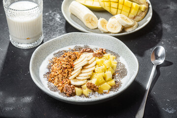 Granola with yogurt, mango, banana and chia in a bowl