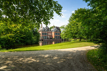 Historic Duivenvoorde castle with a magnificent park in the countryside of Netherlands on a sunny summer day