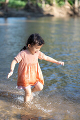 little child playing on water stream