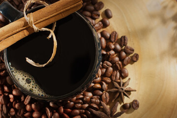 top shot of cup of coffee with cinnamon on wood background.