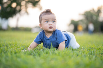 Little boy crawling on the grass