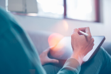 thinking new ideas concept, man holding pen writing idea on computer laptop while sitting in a comfortable position