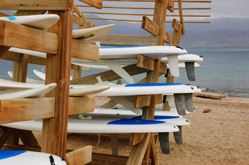Surfboard stack on the beach in  Eilat, Israel. Eilat  is popular winter sun escape destination proposing various leisure and recreation activities. 