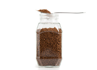 Transparent glass jar with instant granulated coffee on a white background.
