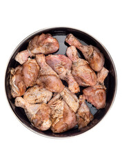 Top view of chicken drumsticks in a pan ready for baking, sprinkled with pepper, salt.