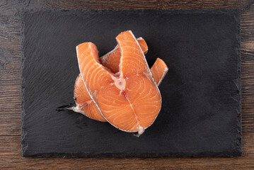 Top view of salmon steaks on a mica serving board.