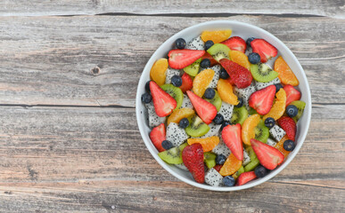Fresh fruit salad bowl on wood grain table concept healthy food, to control weight, to lose weight
